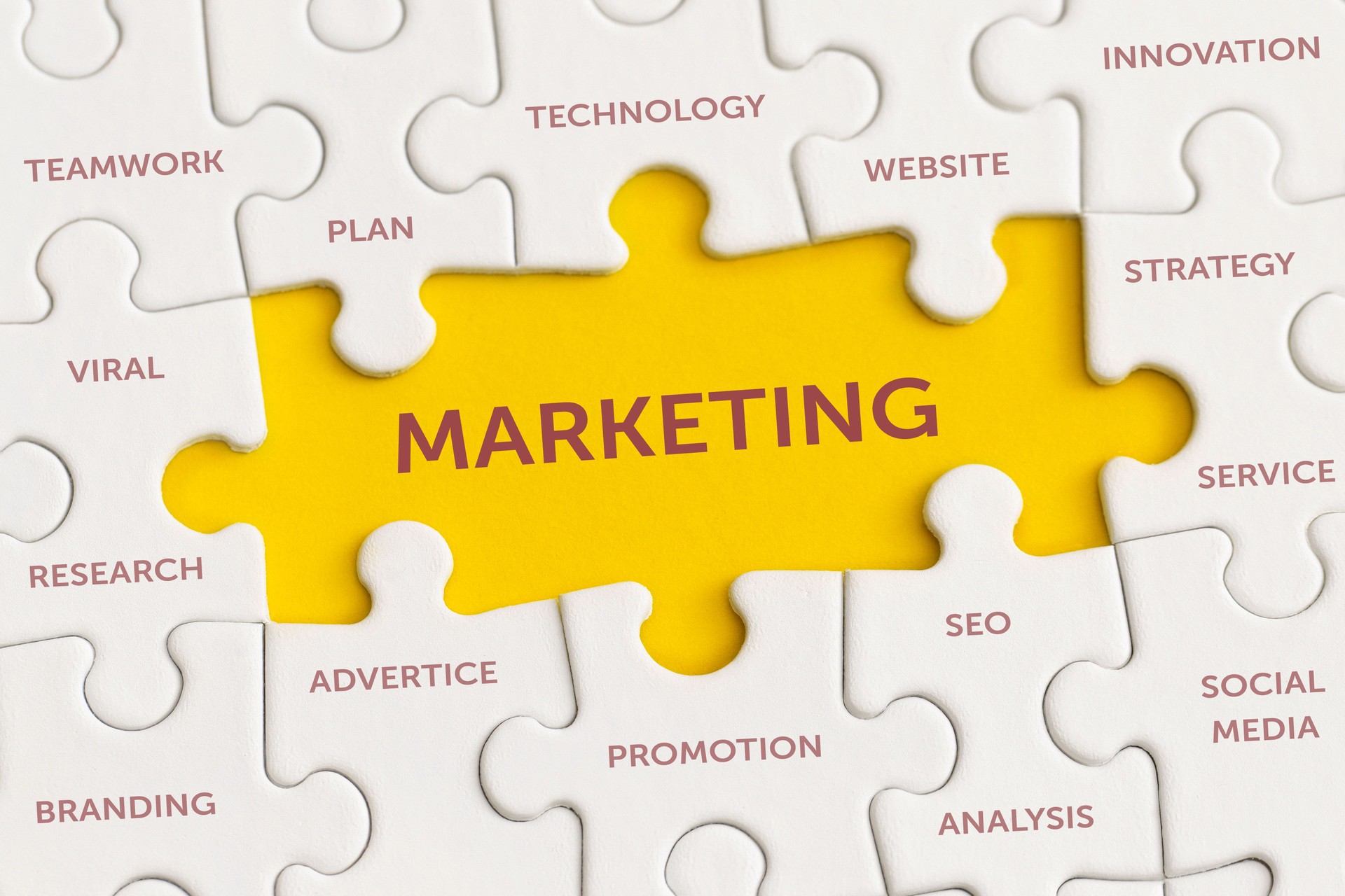 White details of puzzle with the text "Marketing" on yellow background.
